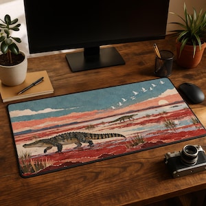 May include: A rectangular desk mat featuring a landscape illustration of crocodiles walking across a red and blue marshland at sunset, with a flock of white birds flying in the sky above the horizon line and distant mountains.