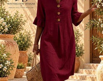 Puede incluir: Un vestido rojo oscuro hasta la rodilla con escote en V, tres botones de madera en la parte delantera central y mangas con volantes hasta el codo. La prenda incluye el texto "WD WINTERLOOM DESIGNS TIMELESS STYLE, WOVEN WITH CARE" en la esquina superior izquierda.