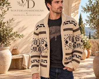 Puede incluir: Una chaqueta de punto color crema con cremallera, cuello chal y un patrón geométrico marrón oscuro en el pecho y las mangas. La prenda de punto se lleva sobre una camiseta gris oscuro con estampado gráfico y vaqueros azul oscuro.