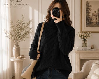 Puede incluir: Un suéter negro de manga larga con cuello alto y un patrón de tejido de punto trenzado en forma de diamante. El suéter se combina con pantalones vaqueros azul oscuro y un bolso de hombro beige y negro con una correa estructurada.