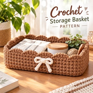 May include: A rectangular brown crochet storage basket with a scalloped edge and a white yarn bow on the front. The text Crochet Storage Basket PATTERN is visible above the basket, which contains a folded cloth, a jar, and a small plant.