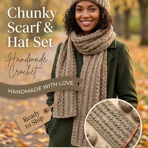 Peut inclure: Un bonnet au crochet beige avec un pompon et une longue écharpe assortie présentant un motif texturé. L'ensemble est présenté avec une étiquette brune marquée Ready to Ship et un encart circulaire montrant le crochet avec une aiguille.