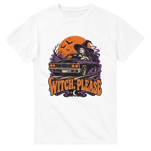 Può includere: Una t-shirt bianca a maniche corte con una stampa grafica che ritrae una persona con un cappello da strega alla guida di un'auto nera d'epoca. Il design include una grande luna arancione, pipistrelli, fumo viola e la scritta arancione "WITCH, PLEASE".