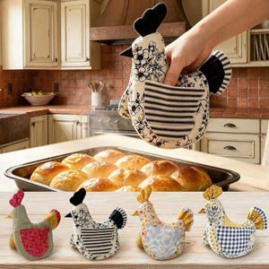 May include: A set of four chicken-shaped fabric oven mitts featuring various floral and geometric patterns. One mitt is held up, showing a black and white floral print with a striped wing pocket. The others display red, blue, and yellow accents.