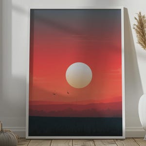 Może przedstawiać: Oprawiony pionowy wydruk ścienny przedstawiający minimalistyczną ilustrację krajobrazu z dużym, bladym, okrągłym słońcem na tle żywego czerwono-pomarańczowego gradientowego nieba, nad ciemną, zarysowaną linią horyzontu wzgórz i płaskiego terenu.