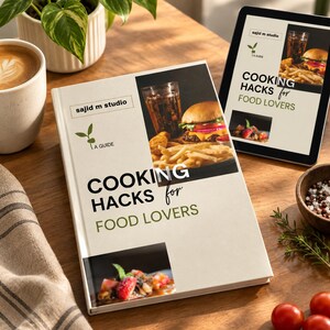 May include: A hardback book titled Cooking Hacks for Food Lovers with a cream cover featuring a green sprout logo, the text sajid m studio, and two food photographs showing a burger with fries and a strawberry dessert, displayed next to a tablet.