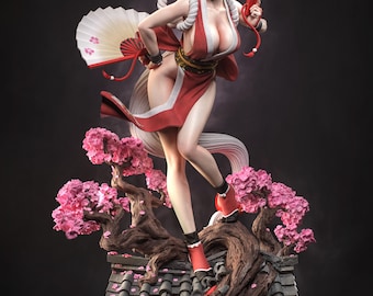 Puede incluir: Una figura coleccionable detallada de un personaje con un atuendo rojo y blanco, sosteniendo dos abanicos. La figura se apoya sobre una base con un tejado de tejas oscuras, un tronco de árbol nudoso y flores de cerezo rosas.