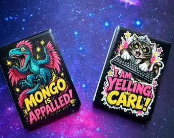 May include: Two rectangular magnets with black backgrounds. The left magnet features a teal dinosaur with pink feathers and the text "MONGO IS APPALED!". The right magnet shows a cat wearing a crown and glasses at a keyboard with the text "I AM YELLING CARL!".