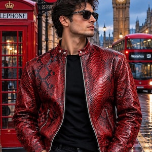 May include: A red and black snakeskin-patterned leather jacket with a stand-up collar, silver-toned front zipper, and two zippered side pockets. The jacket is worn over a plain black t-shirt and paired with dark denim jeans and black sunglasses.