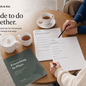 Printed Everything in Place pages and cover on a table as two family members complete the organizer together with pens and tea.