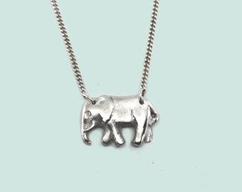 May include: A silver necklace with a small elephant pendant.