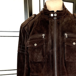 May include: A brown suede leather jacket with a zipper closure and multiple pockets.