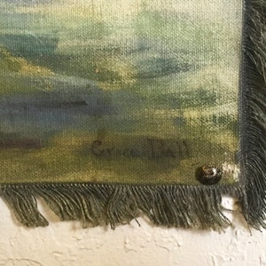 May include: An abstract painting in shades of green and blue with a fringed edge and a small metal tag. The painting is signed "G.C. Hall" in the bottom right corner.