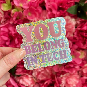 May include: A holographic sticker with pink glitter and the text "YOU BELONG IN TECH" in white letters.