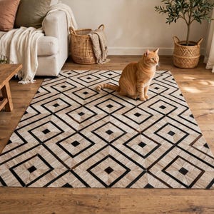 May include: A rectangular area rug featuring a repeating geometric pattern of black and beige diamonds. The rug is constructed from stitched panels of hide, creating a textured surface with sharp, clean lines and a consistent diamond motif.