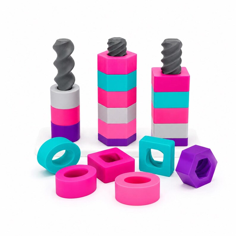 May include: A set of three vertical threaded gray rods with stacked geometric shapes in bright pink, purple, turquoise, and light gray. The shapes include circular and hexagonal rings, some of which are scattered in the foreground.