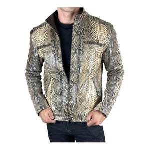 Könnte beinhalten: Eine Jacke mit Schlangenledermuster in Beige-, Braun-, Grau- und Schwarztönen. Das Kleidungsstück verfügt über einen Stehkragen, einen durchgehenden Frontreißverschluss und zwei horizontale Reißverschlusstaschen im Brustbereich mit dunkelbraunem Innenfutter.