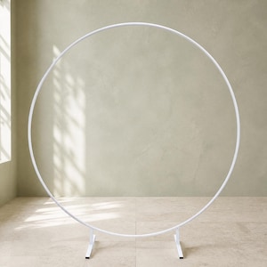 Peut inclure: Un grand support circulaire en métal blanc conçu pour les présentations événementielles. La structure se compose d'un cerceau fin et continu soutenu par deux petits pieds métalliques rectangulaires à la base, assurant une assise stable.