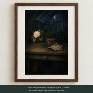 May include: A framed 12 x 18 inch digital artwork depicting a white camellia flower in a terracotta pot on a wooden workbench inside a dark greenhouse. A pair of beige gardening gloves rests on the table next to the plant, with a dark background.
