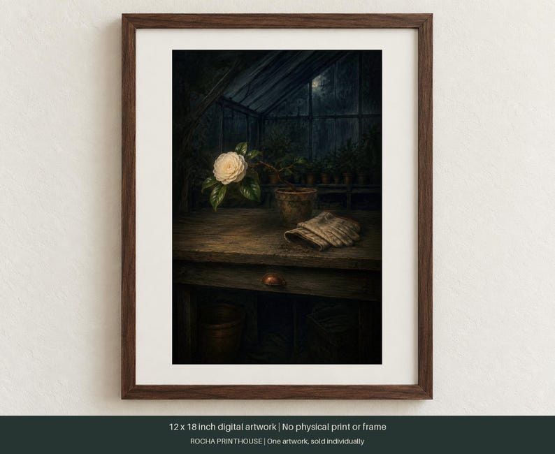 May include: A framed 12 x 18 inch digital artwork depicting a white camellia flower in a terracotta pot on a wooden workbench inside a dark greenhouse. A pair of beige gardening gloves rests on the table next to the plant, with a dark background.