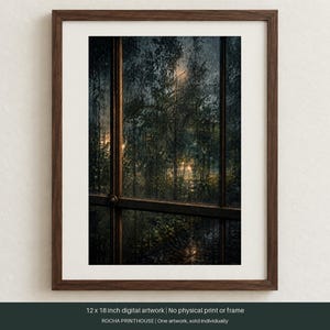 May include: A framed 12 x 18 inch digital artwork depicting a view through a window pane at night. The scene shows dark, rain-streaked glass looking out onto foliage illuminated by soft, warm light. The frame is dark brown wood with a white mat.
