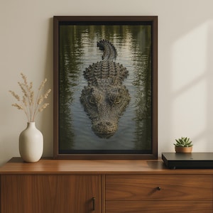 Puede incluir: Una impresión artística enmarcada que presenta una fotografía detallada de un gran cocodrilo nadando en aguas oscuras y onduladas. El reptil está centrado, mostrando sus escamas texturizadas de color verde oscuro y marrón, con los ojos visibles.