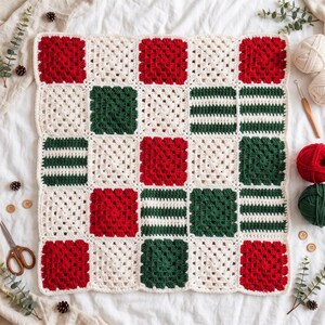 May include: A square crochet blanket featuring a grid of alternating blocks in red, dark green, and cream white. The pattern includes solid granny squares and striped sections, all joined together with a cream white border.
