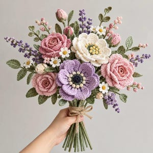 May include: A crochet flower bouquet featuring pink and white roses, a central purple anemone, small white daisies, and sprigs of purple lavender. The stems are wrapped in green yarn and tied with a thin, light brown jute twine bow.