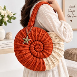Könnte beinhalten: Eine runde, spiralförmige Häkeltasche in einem zweifarbigen Design aus gebranntem Orange und Creme. Die Tasche hat ein strukturiertes Rippenmuster und einen goldfarbenen Seestern-Anhänger aus Metall, der mit einer feinen Kette am Griff befestigt ist.