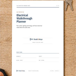 May include: A white paper document titled Electrical Walkthrough Planner with dark blue text, featuring sections for project records, homeowner, property, and builder details, accompanied by a set of metal keys and a measuring tape on a wooden surface.