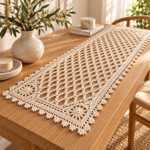 May include: A rectangular cream-colored crochet table runner featuring an intricate diamond-shaped lattice pattern throughout the center, bordered by a decorative edge with small floral motifs and scalloped detailing along the entire perimeter.