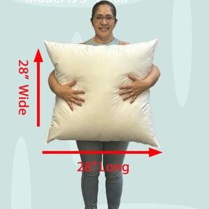 Lady holding a small 28x28 pillow insert to demonstrate the size of the pillow form and how do I correctly measure my sham.  What size insert does an 26x26 sham need?  28 by 28 pillow inserts best fits a 26 by 26 decorative pillow sham.  What size pillow does my decorative sham need.  What size pillow insert does my 27 by 27 pillow cover need?