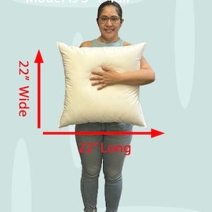Lady holding a small 22x22 pillow insert to demonstrate the size of the pillow form and how do I correctly measure my sham.  What size insert does an 20x20 sham need?  22 by 22 pillow inserts best fits a 21 by 21 decorative pillow sham.  What size pillow does my decorative sham need.  What size pillow insert does my 20 by 20 pillow cover need?