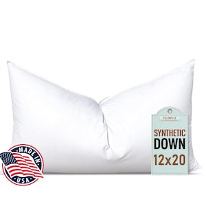 May include: A white pillow with a tag that reads "Synthetic Down 12x20". The pillow is made in the USA.