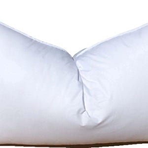 May include: A large, white pillow with a rectangular shape. The pillow is made of a smooth, soft material and appears to be filled with a fluffy substance. The pillow is designed for sleeping and resting. The image includes a "Made in USA" sticker.