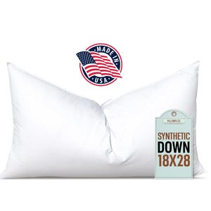 May include: A white, rectangular pillow with a tag that reads "Synthetic Down 18x28". The pillow is made in the USA, as indicated by a circular label with an American flag and the words "Made in USA".
