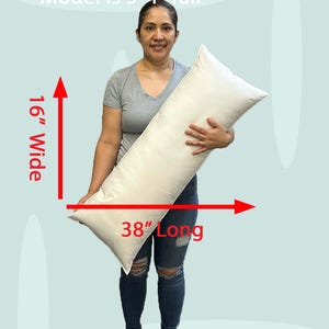 Lady holding an 16x38 pillow insert to demonstrate the size of the pillow form and how do I correctly measure my sham.  What size insert does an 15x37 lumbar sham need?  16 by 38 pillow inserts best fits a 16 by 36 decorative pillow sham.  What size pillow does my decorative sham need.  What size pillow insert does my 15 by 37 travel pillow cover need?