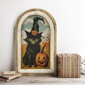 May include: A framed vintage Halloween print depicting a black cat wearing a witch's hat and holding a jack-o'-lantern. The print is displayed on a rustic wooden shelf with a stack of books and a clock.