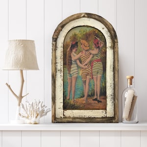 May include: A vintage-style framed print of three women in striped bathing suits standing by a lake. The frame is distressed wood with a whitewash finish.