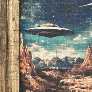 May include: A framed painting depicting a desert landscape with a flying saucer hovering over a canyon. The sky is a deep blue with stars and a comet. The desert is a warm brown with cacti and mountains in the distance.