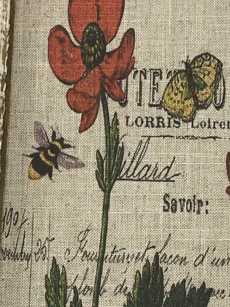 May include: A vintage-style print featuring a red poppy flower, a bee, and a butterfly. The print has a linen texture and includes the text "L'Atelier de L'Orris" and "Savoir".