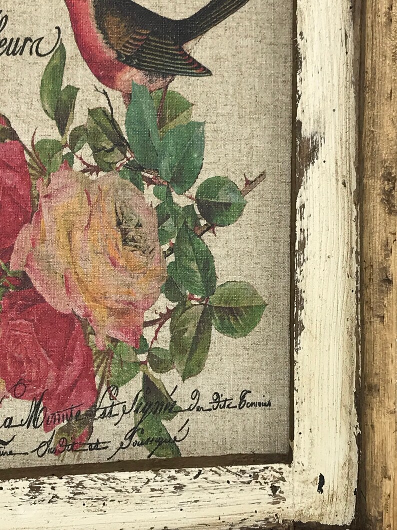May include: A framed print with a vintage aesthetic featuring a bird perched on a branch with roses. The print has a distressed white frame and the text "La Musique est l'&acirc;me de l'univers" is visible in the bottom right corner.