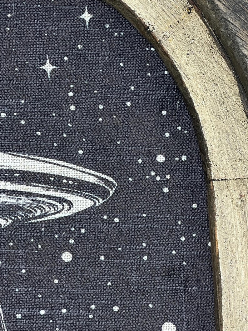May include: A black and white illustration of a flying saucer against a dark blue background with white stars. The image is framed in a gold-painted wooden frame.