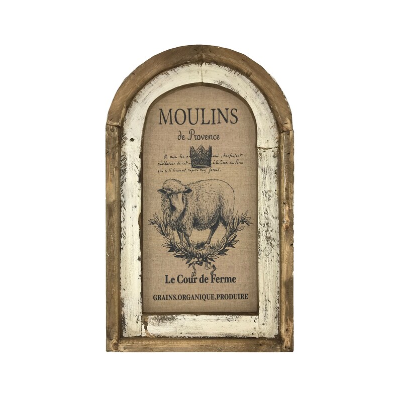 Op de afbeelding: Een rustiek houten ingelijst bord met een witgekalkte afwerking. Het bord heeft een jute achtergrond met een zwart-witte illustratie van een schaap en de tekst "Moulins de Provence Le Cour de Ferme GRAINS.ORGANIQUE.PRODUIRE".