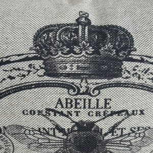 May include: A black and white illustration of a bee with a crown above it. The text "Abeille Constant Crepaux" is printed below the bee.