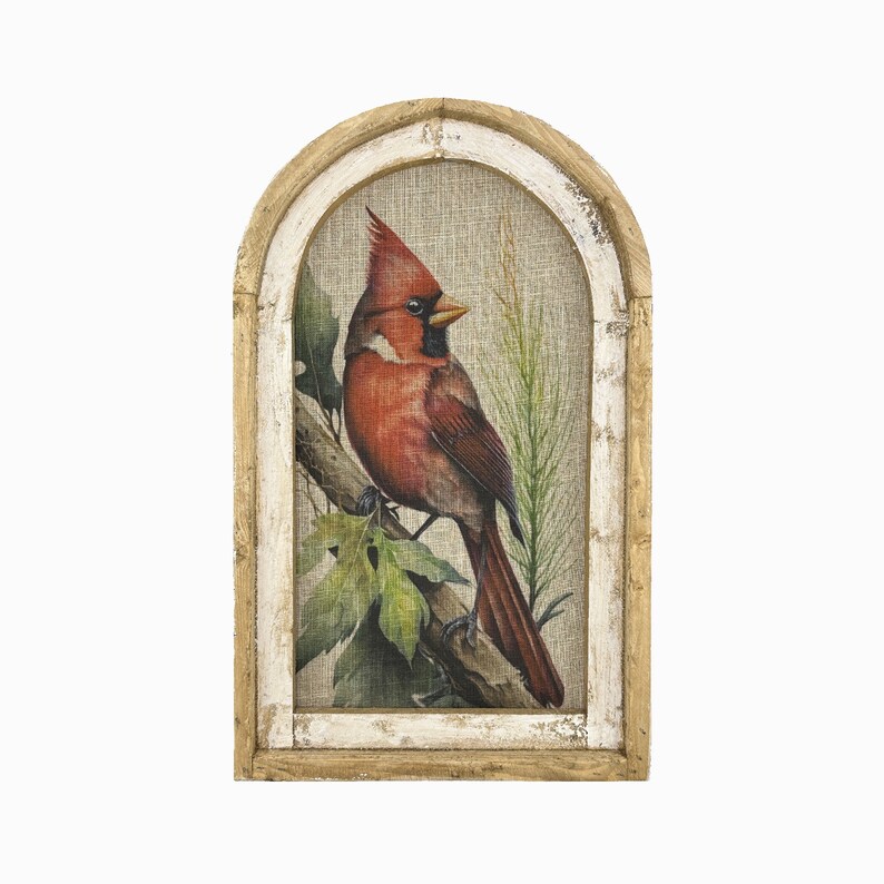 May include: A framed print of a cardinal perched on a branch with green leaves. The frame is a rustic wood with a whitewash finish and an arched top.
