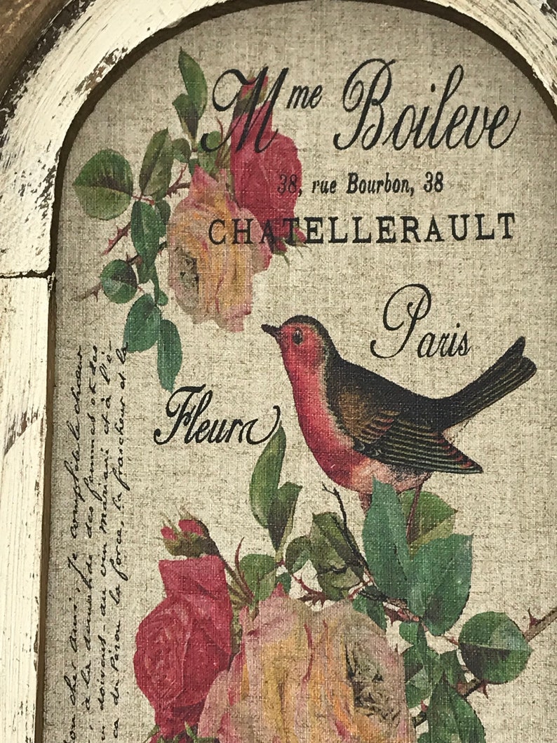 May include: A vintage-style print featuring a robin perched on a branch with pink and yellow roses. The print includes the text "Mme Boileve 38, rue Bourbon, 38 CHATELLERAULT Paris Fleur".