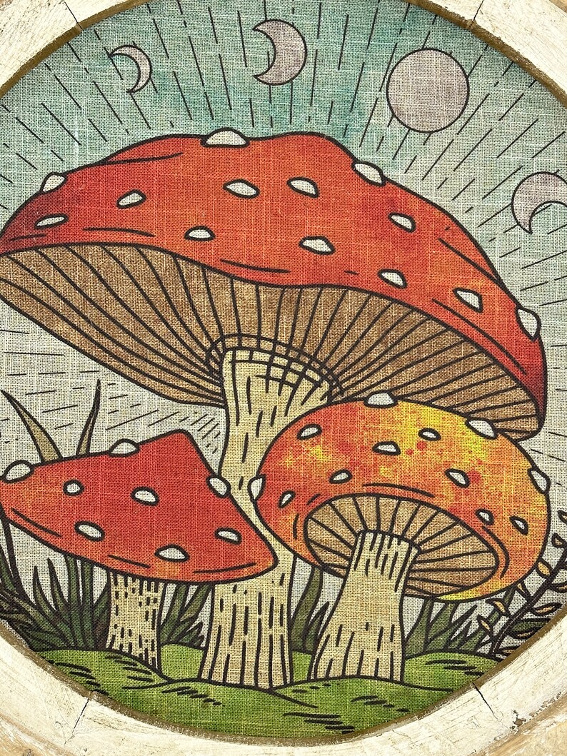 May include: A vintage-style illustration of three red and yellow mushrooms with white spots, set against a blue and green background with crescent moons and a sun.