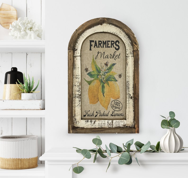 May include: A rustic wooden sign with a whitewashed finish and an arched top. The sign features a burlap background with a vintage illustration of lemons and the text "Farmers Market", "100% organic", and "Fresh Picked Lemons".