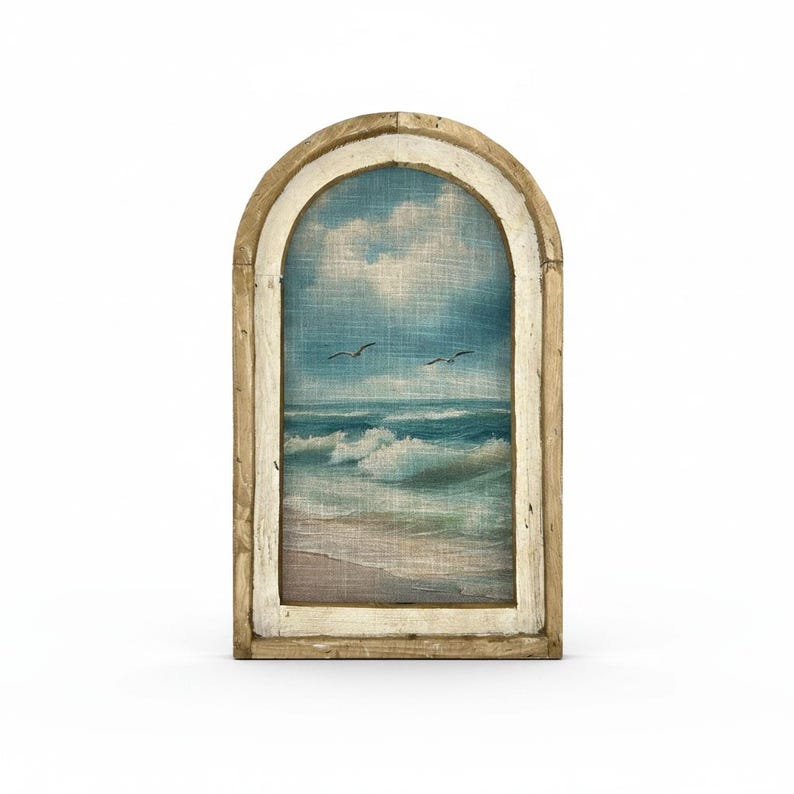 a painting of a beach scene with waves crashing on the shore, framed in an arched wooden frame.